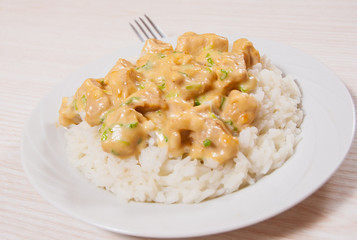 Pieces of chicken fillet and cheese sauce with rice