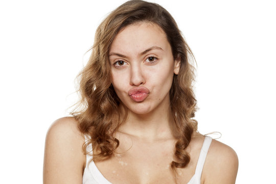 young woman without make-up with pursed lips