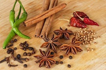 Spices - star anise, green chili, pepper, cinnamon and other spices - wood background