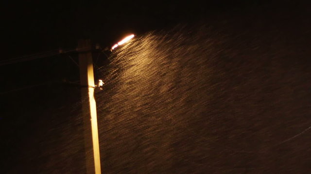 Snow Storm at Night on the Background of a Lamppost.