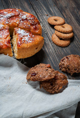 Homemade apple pie and cookies on the wooden rustic background