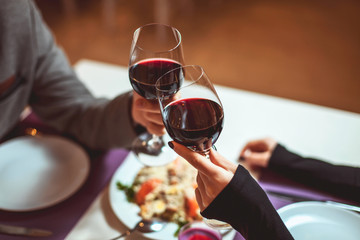 Schönes junges Paar mit Gläsern Rotwein im Luxusrestaurant