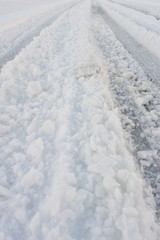 Fototapeta na wymiar Grooves of the tire in the snow road