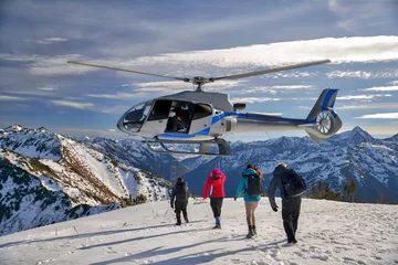 Poster De helikopter zweefde boven de berg mama. 4 personen ontsnappen en klimmen aan boord van een helikopter. © Vladimir Smirnov