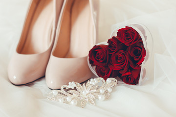 wedding shoes with rings and red rose petals