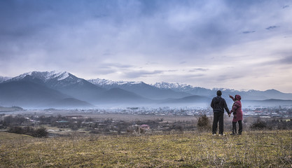Georgia, Kakheti, Alazani Valley. Man and woman admiring a mountain landscape.