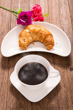 hot coffee and croissant on wooden