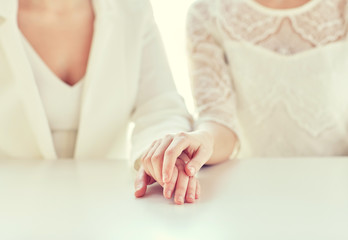 close up of happy married lesbian couple hands