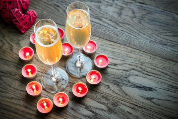 Two glasses of champagne inside of burning candles