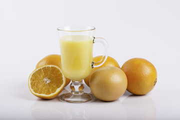 glass of juice and a sliced orange on white