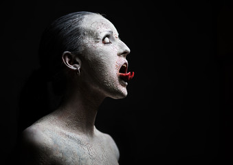 female demon.Art studio shot.Goth girl with sliced tongue