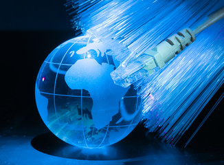 glass earth with network against fiber optic background