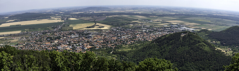Fototapeta premium Teen going on a zip line adventure above a valley. Teen boy going on a zip line adventure above a valley. Forest lay below and in the distance there are cultivated fields.