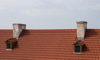 Red roof and two chimney against the sky © yaslex