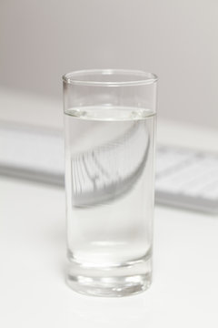 Glas Wasser auf Schreibtisch