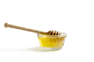 Jar of honey with a wooden drizzler, lemon and anise on the wooden backgrond