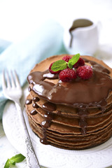 Chocolate pancakes with raspberry and chocolate sauce.