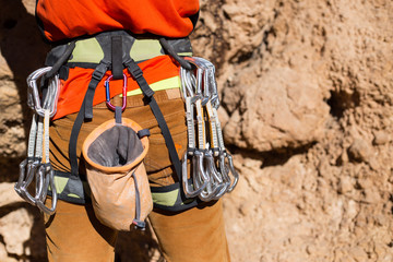 Young male climber hanging by a cliff.