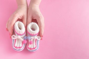 Female hands carefully holing baby shoes