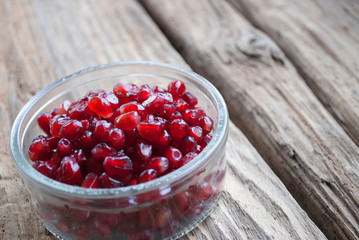 Schale mit Granatapfel auf Treibholz / Holz Hintergrund 