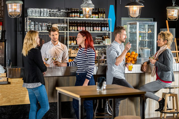Bartender With Customers Having Drinks In Bar