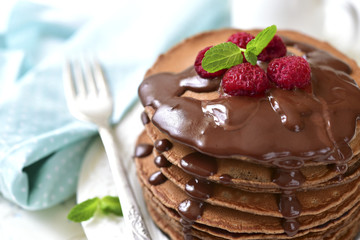 Chocolate pancakes with raspberry and chocolate sauce.