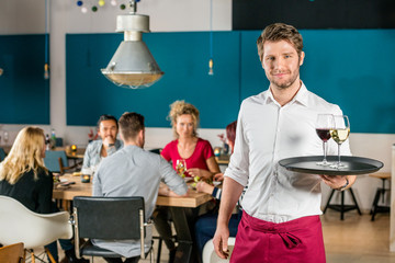 Confident Waiter Holding Tray At Restaurant