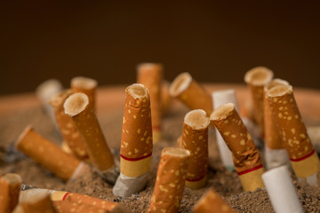 Pollution,Smoking,Danger,Brown ashtray with cigarette stubs in closeup.