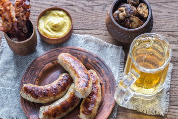 Grilled sausages with fried bacon rashers and mushrooms