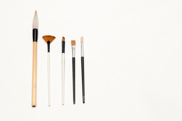 Artists brushes and pens displayed on isolated white background