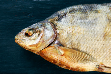 Salted Dry fish vobla on blue stone background