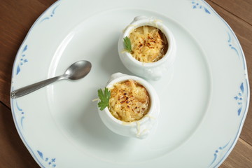 Onion soup served in porcelain bowls
