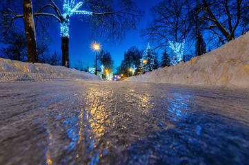 Blank big rink at night. Frozen road close up