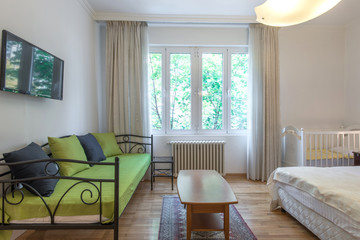 Hotel suite interior, Green sofa in bright contemporary apartment