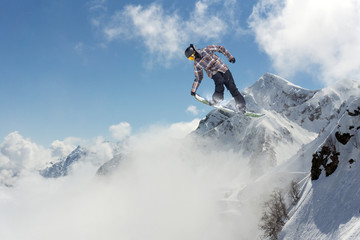 Naklejka na ściany i meble Flying snowboarder on mountains. Extreme sport.