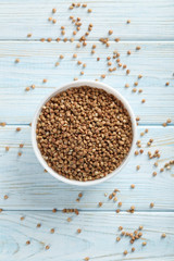 Buckwheat seeds in bowl on a blue wooden table