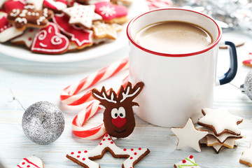 Christmas cookies with cup of hot coffee on a blue wooden table