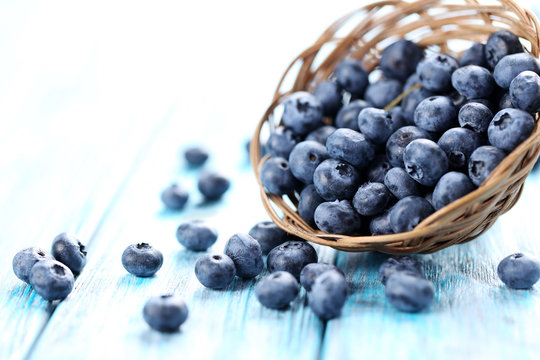 Blueberries in basket on a blue wooden table