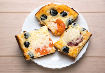 Homemade pizza with ham cheese olives tomatoes on wooden table