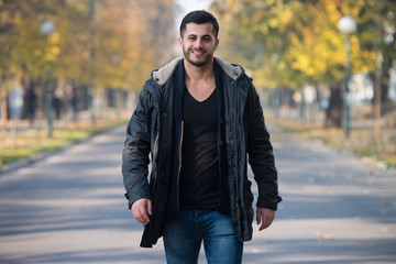 Young Man Walking In Autumn Forest