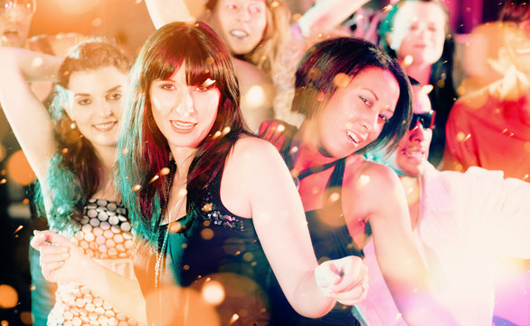 Frauen und Männer tanzen im Disco Club bei Party