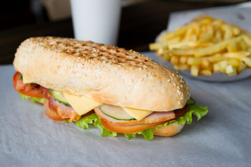 delicious sandwich with shank , cheese, tomato , lettuce and cuc