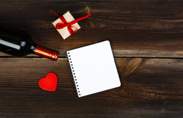 Red Wooden Heart, Bottle Of Wine, Gift Box And Notepad On Old Wooden Board. Love Concept. Valentines Day Background.