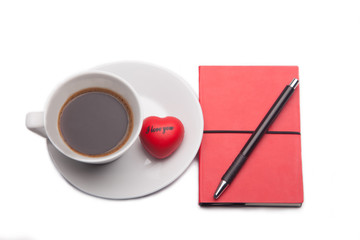 coffee cup and red notebook and pen