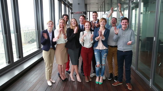 Portrait of happy business and advertising team laughing and clapping 