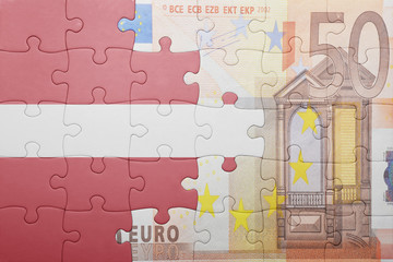 Obraz premium puzzle with the national flag of latvia and euro banknote