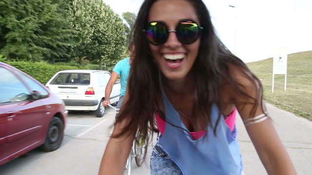 Beautiful woman sending kisses while cycling with friends