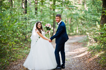 Young lovely wedding couple at the wood