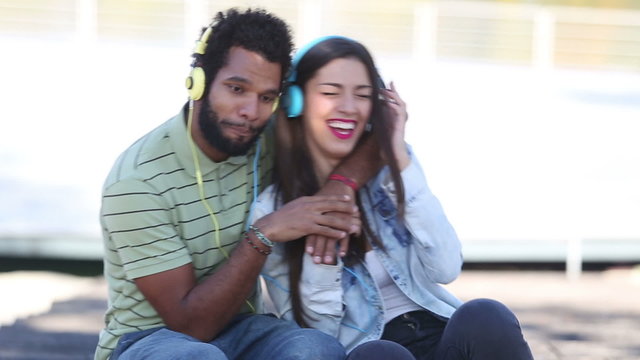 Attractive couple having fun listening to music with headphones 