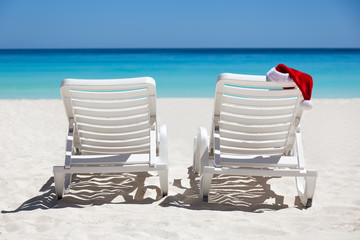 Santa Claus Hat on sunbed near  tropical calm beach with turquoi
